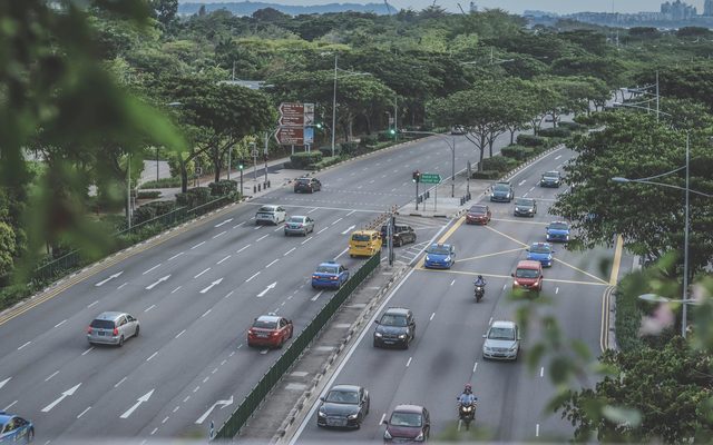 Traffic on a tree-lined Singapore expressway, seen from above