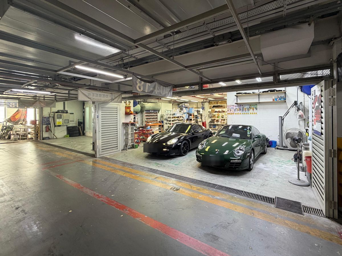 The workshop bays seen from the drive, with two cars inside